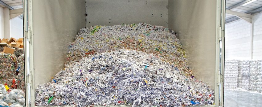 A pile of shredded paper in front of a wall.